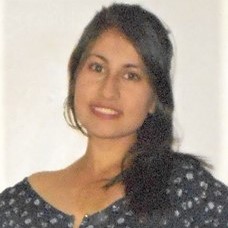 la imagen puede contner a una mujer de cabello negro ,posando de pie ligeramente sonreida